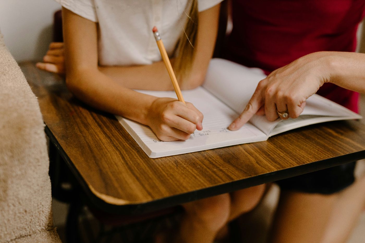 An adult taking notes at a table while a child plays nearby, representing a guardian ad litem investigation in a South Carolina custody case.