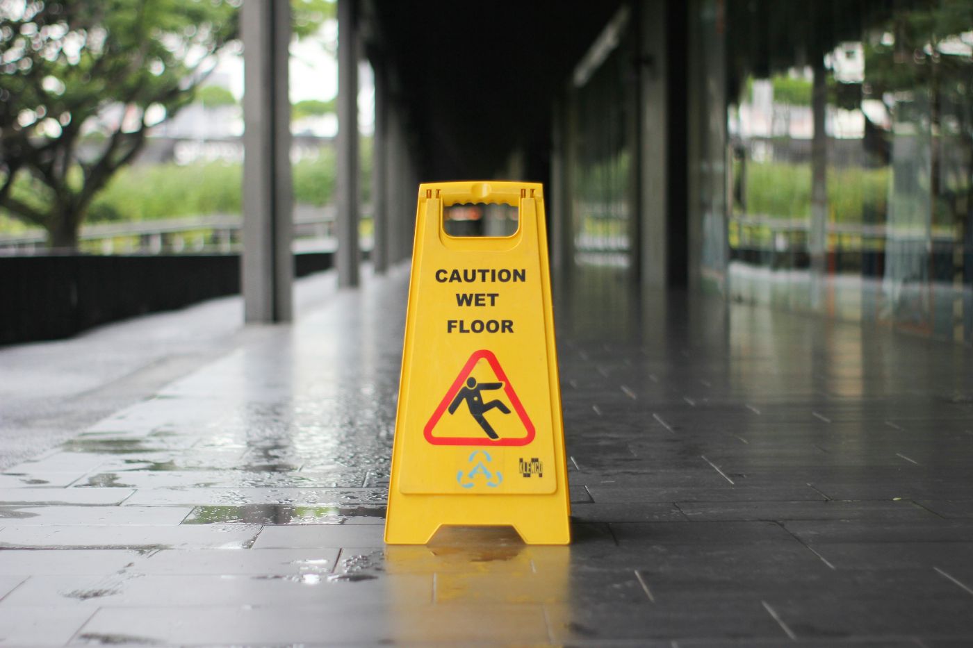 A wet floor sign beside a puddle in a store aisle, illustrating premises liability in South Carolina.