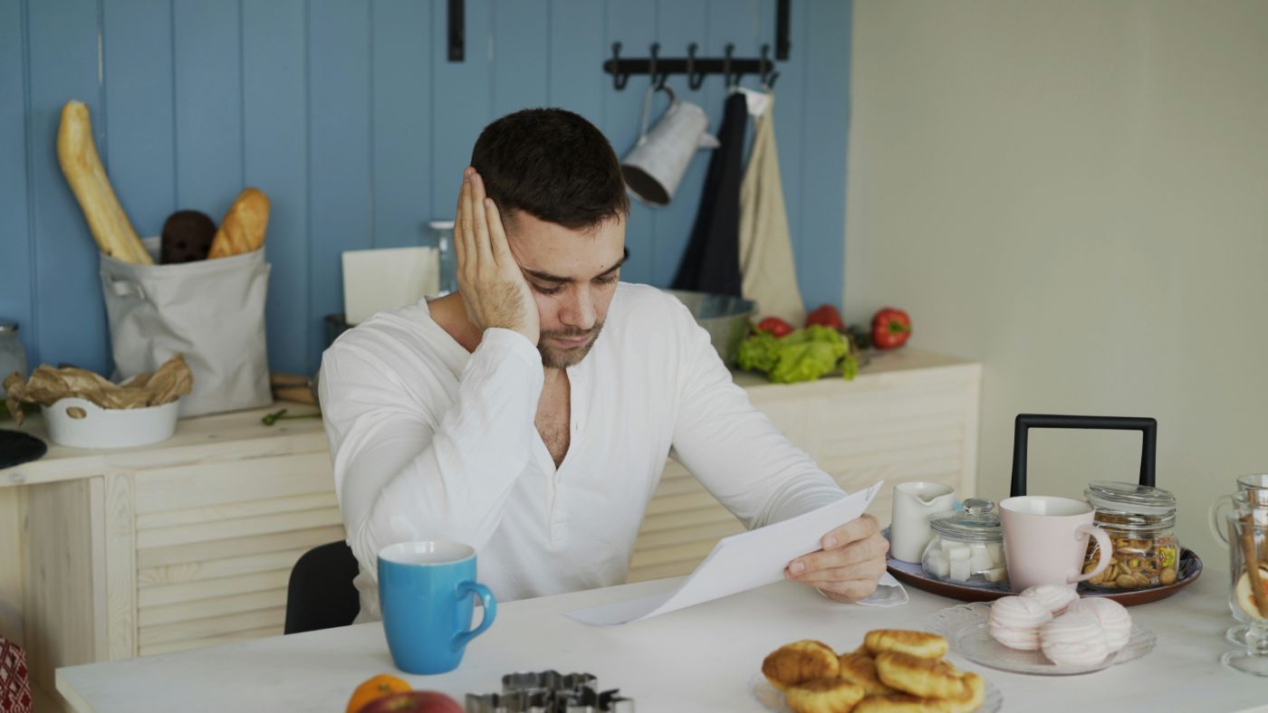 A parent reviews a child support worksheet and pay stubs at a kitchen table, illustrating how child support is calculated in South Carolina