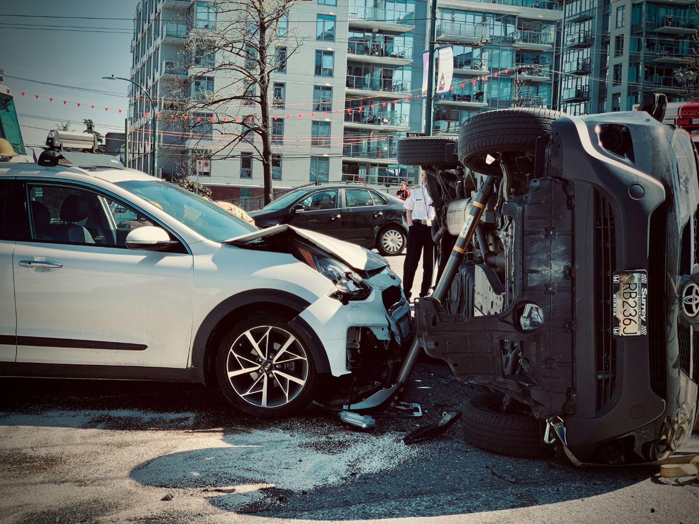 A white car and an overturned SUV after a two-car collision on a city street, illustrating passenger rights after a car accident in South Carolina