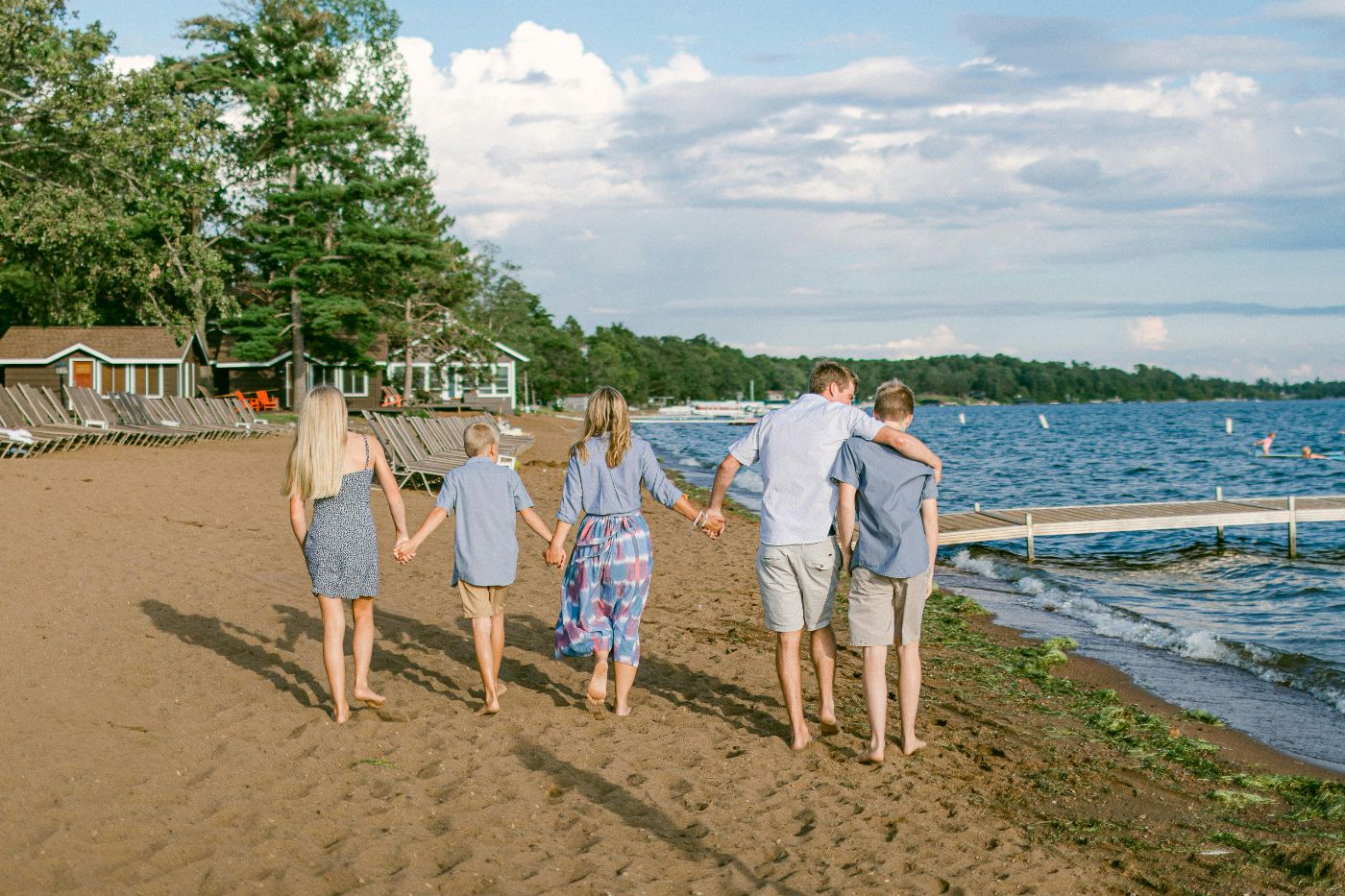 A family walking on the beach holding hands during a week of Rule 615 secure leave