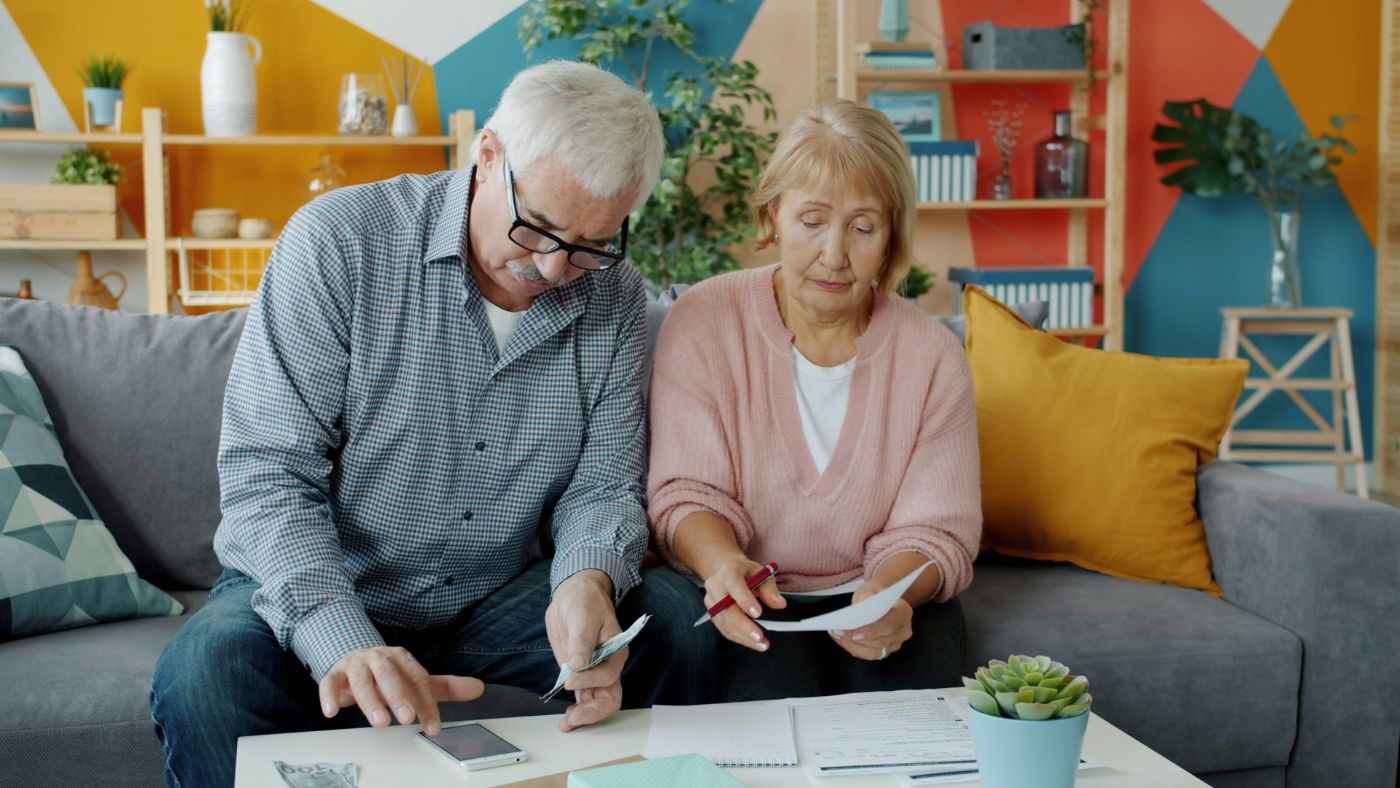 An older couple’s financial paperwork and a calendar, representing modifying alimony in South Carolina.