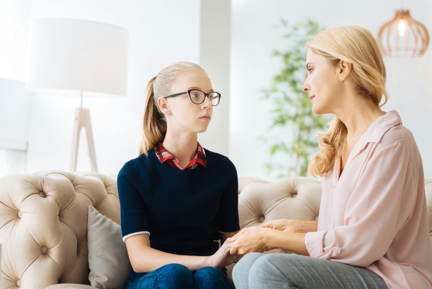 A teenager sitting at a kitchen table with a parent, representing whether a child can choose which parent to live with in South Carolina.
