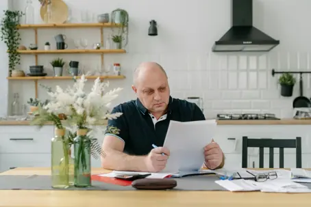 Man looking at bills at table