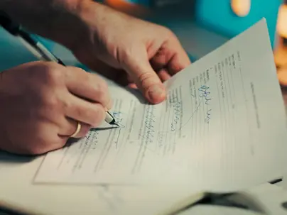 Someone writing on a document