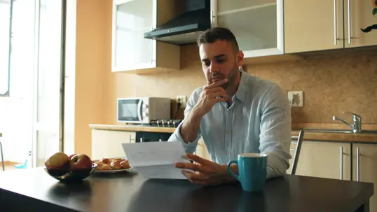 Man reading a document at his kitchen table
