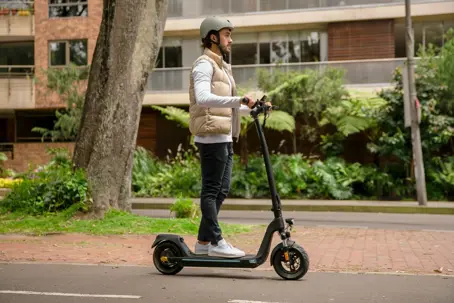 A helmeted rider on an electric scooter beside a city street, illustrating an electric scooter accident in South Carolina.