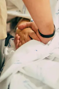 Holding someone's hand in the hospital