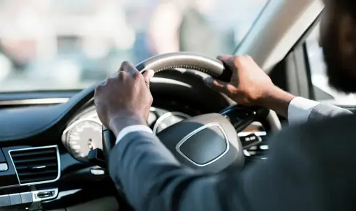 someone with their hands on a steering wheel